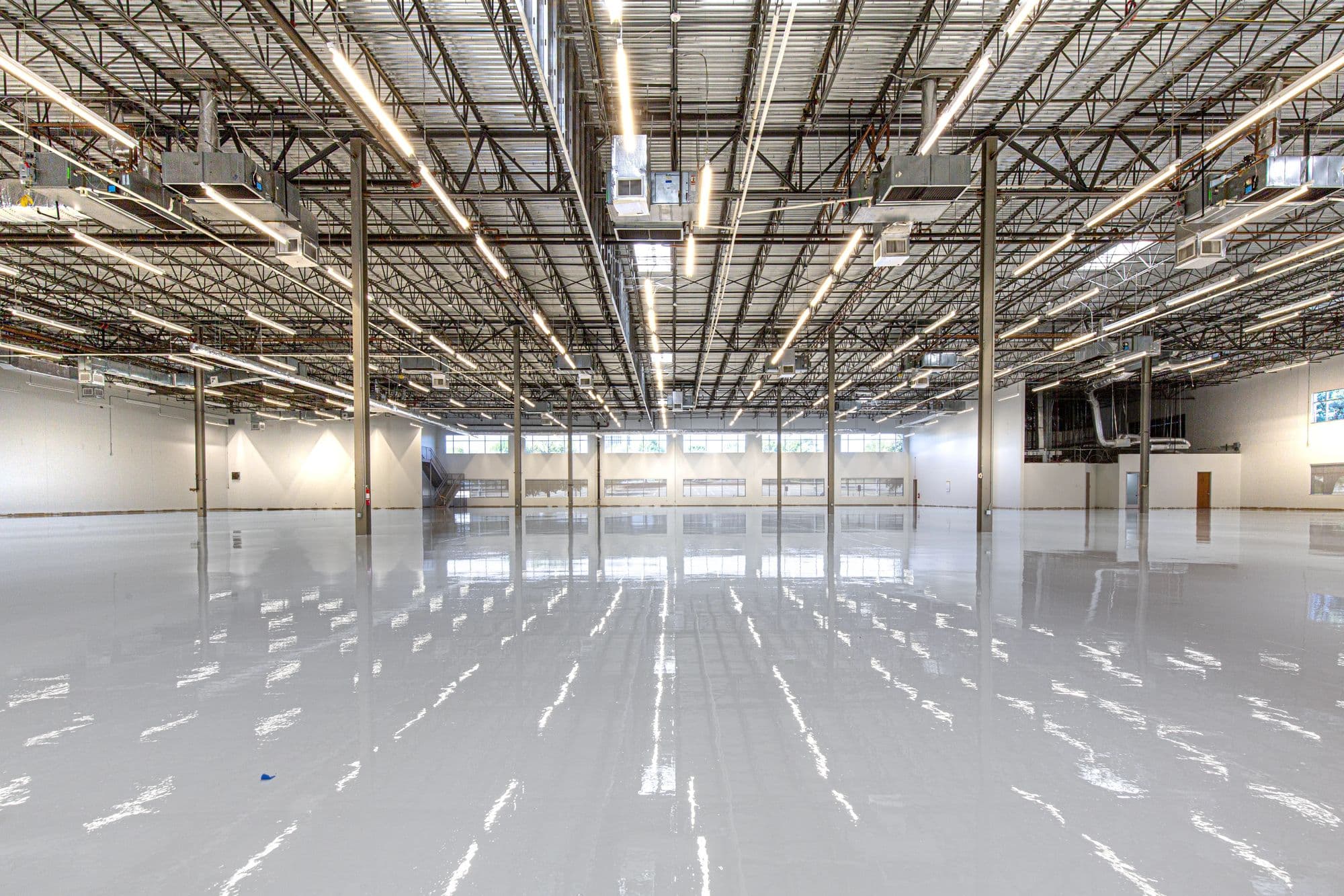 Large seamless epoxy floor across an open workshop space