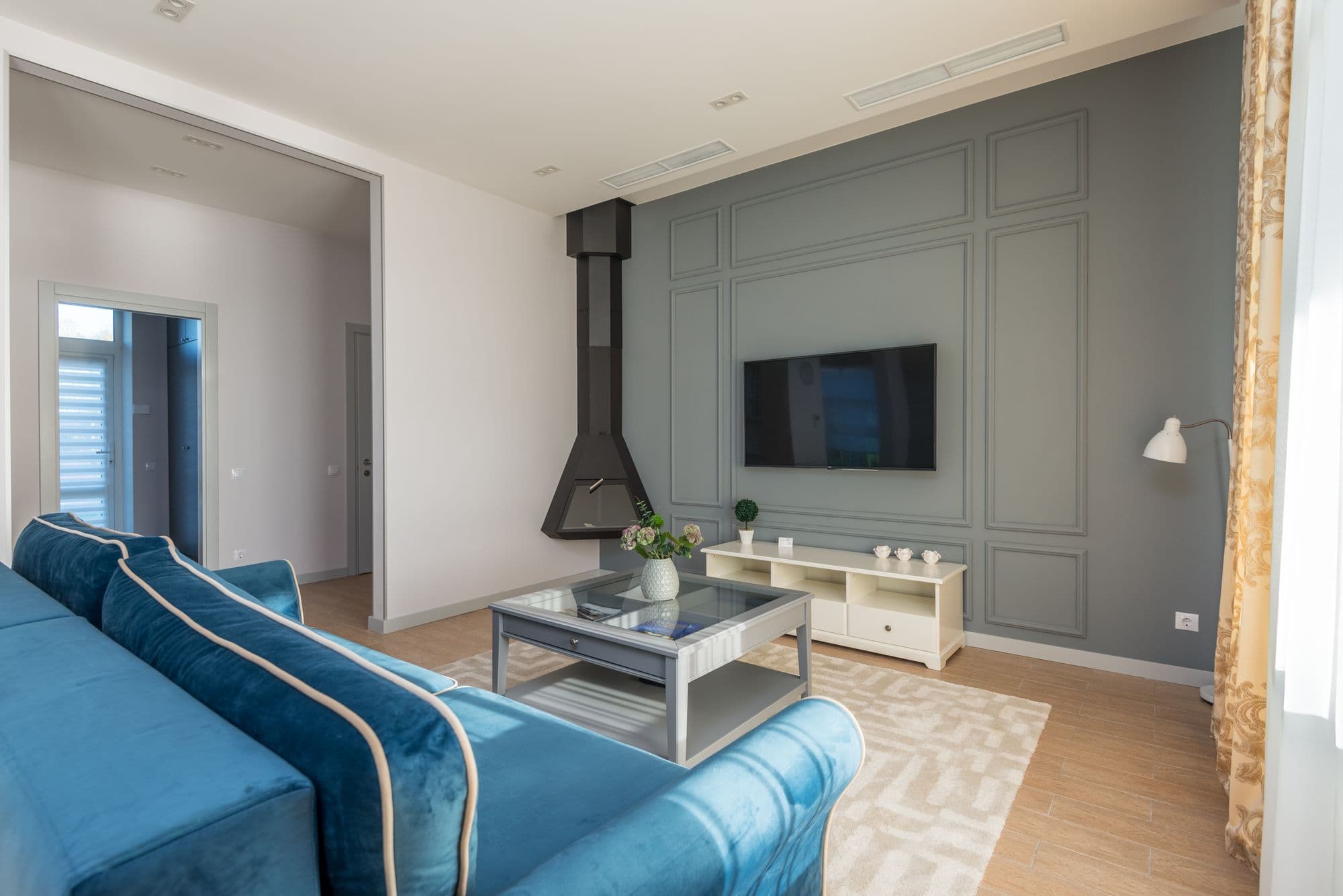 Flat-screen television mounted on a living room wall above a low sideboard