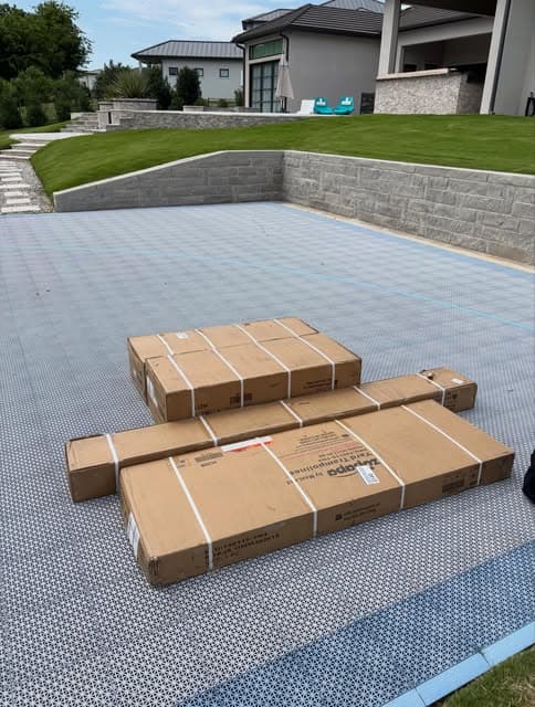 Boxed outdoor patio furniture delivered onto a paved backyard patio