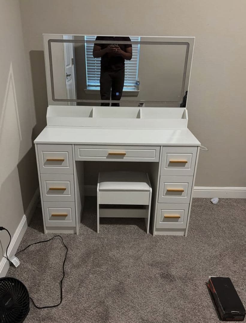 White vanity desk with a wide mirror, gold handles and matching stool